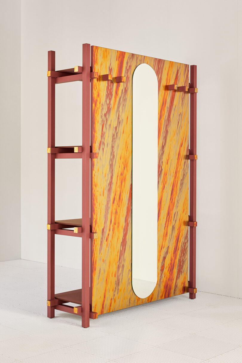 A colorful piece of furniture with a mirror, flanked by wooden shelves on the reverse side.