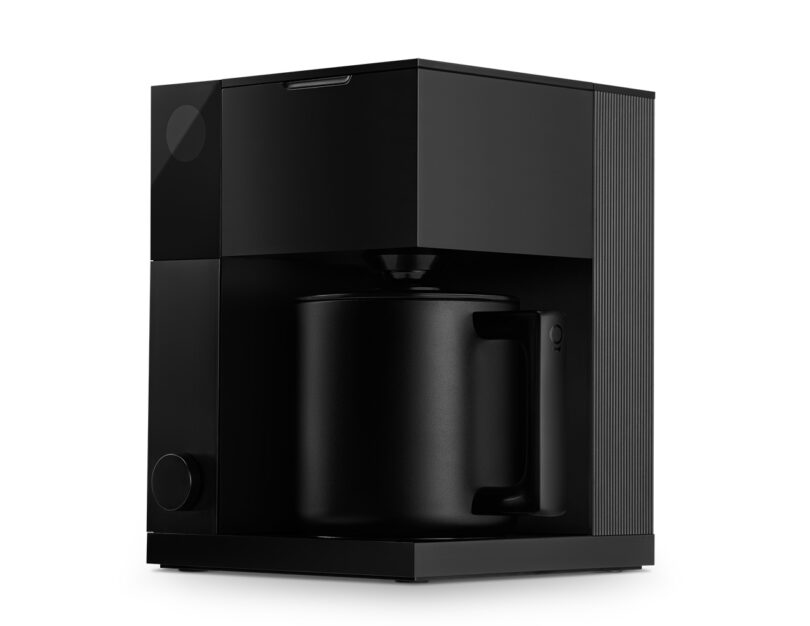 All matte black Fellow Aiden automatic drip coffee maker with carafe from angled perspective.