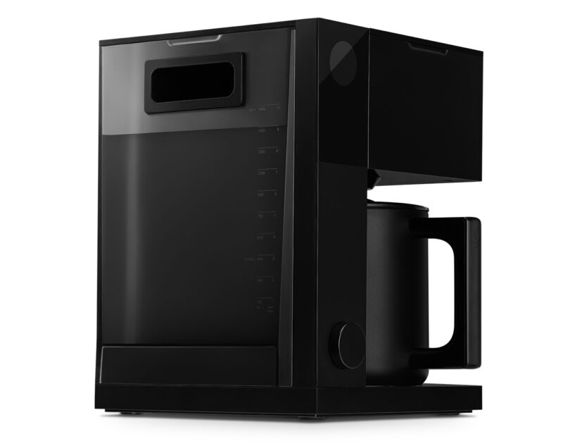 Rear view of the Fellow Aiden drip coffeemaker isolated on a white background, showing its water basin and measuring units printed across its back.