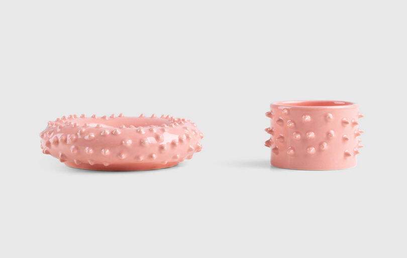 pink spiky ceramic cup sitting next to its matching saucer