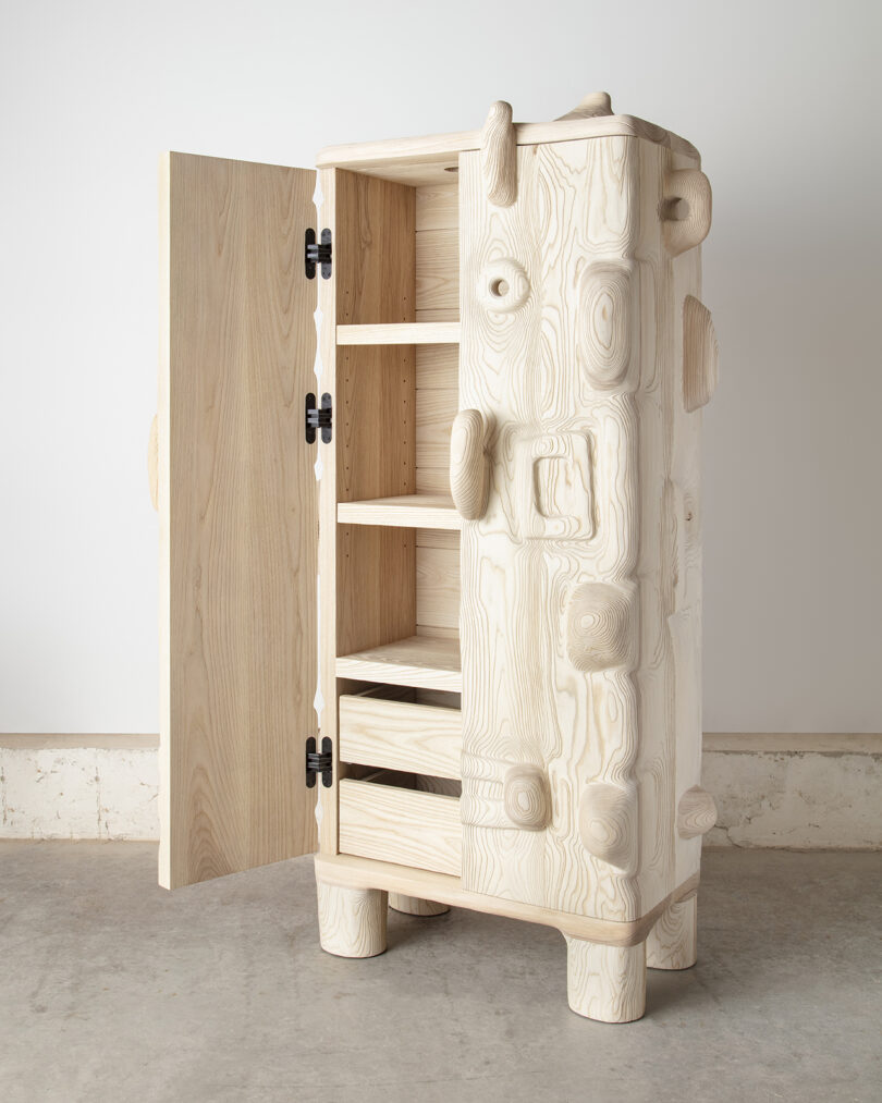 A wooden cabinet with an abstract, sculptural design featuring prominent, exaggerated wood knots and textures.