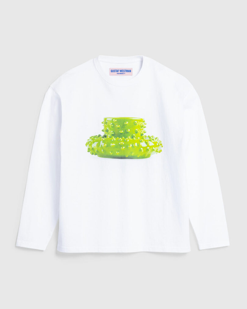 White long-sleeve t-shirt featuring a Gustaf Westman green mug and saucer on the chest.