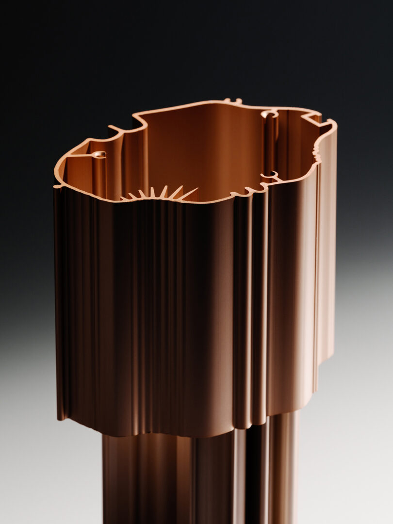 Detail of a cylindrical, fluted table lamp in copper.