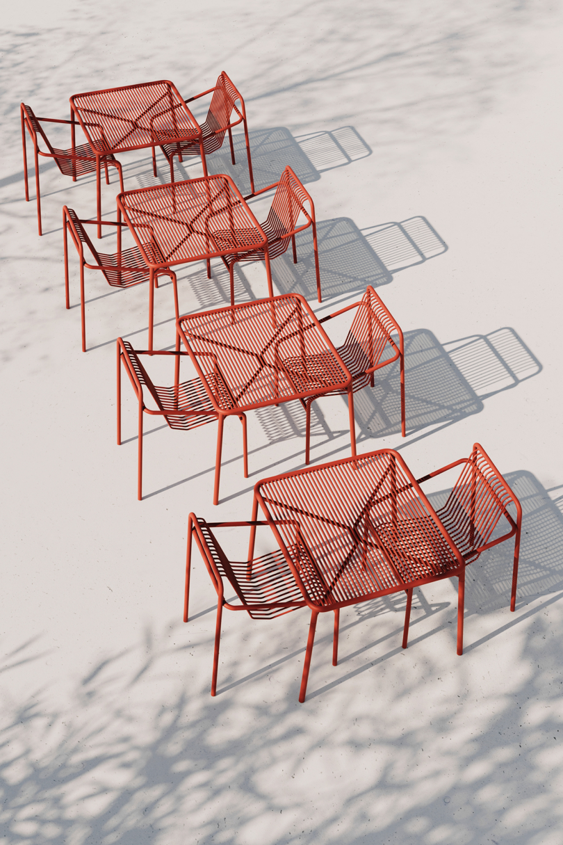 Modern red outdoor furniture casting shadows in sunlight.