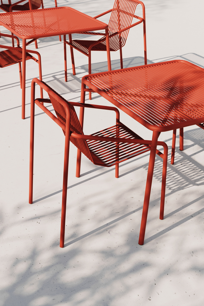Modern red outdoor furniture casting shadows in sunlight.