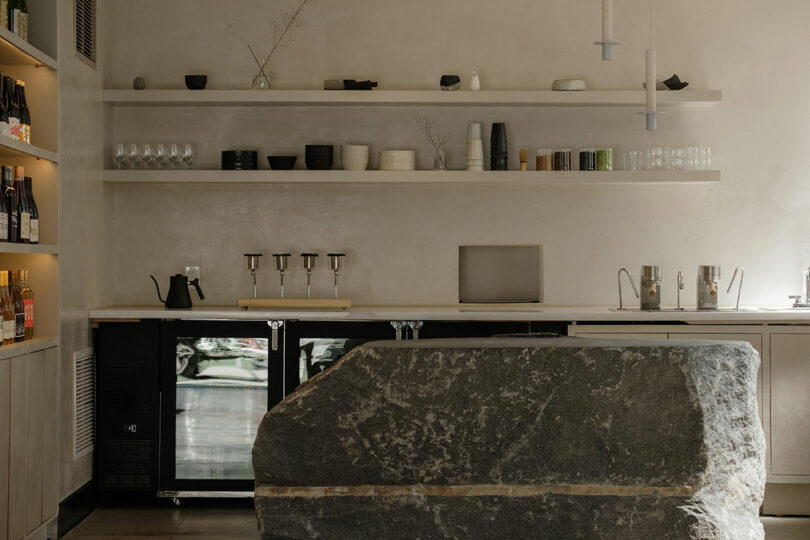 Modern minimalist kitchen with neutral tones and an oversized stone island centerpiece.