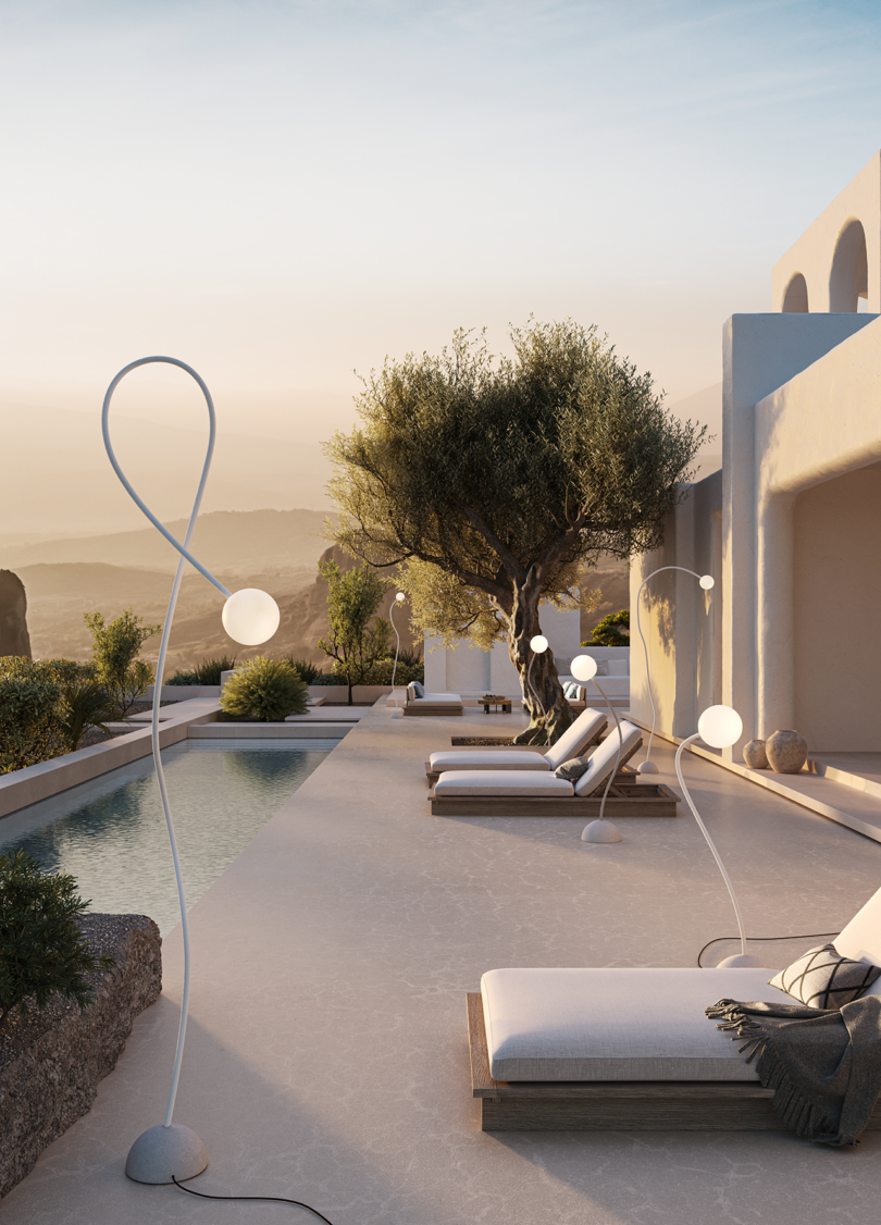 A poolside with modern outdoor lighting, loungers, and an olive tree during sunset.