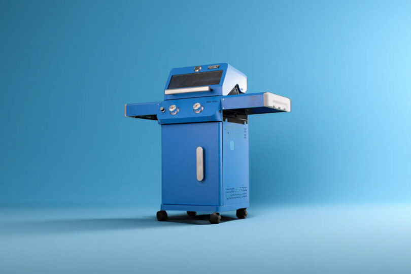 Blue Monument Grills Mesa Collection propane gas grill with both side tables extended out staged against a blue background.