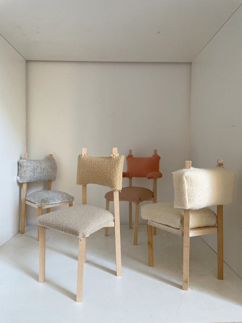 Five miniature chair mockups with textured upholstery in varying colors, displayed in a white box setup.