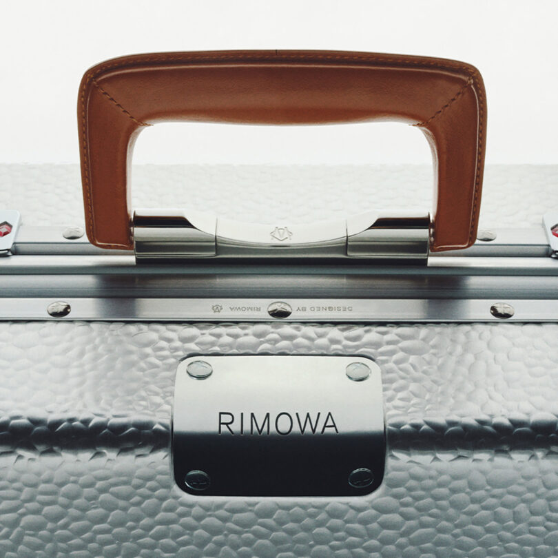 Close-up of a Rimowa aluminum luggage handle and latch.