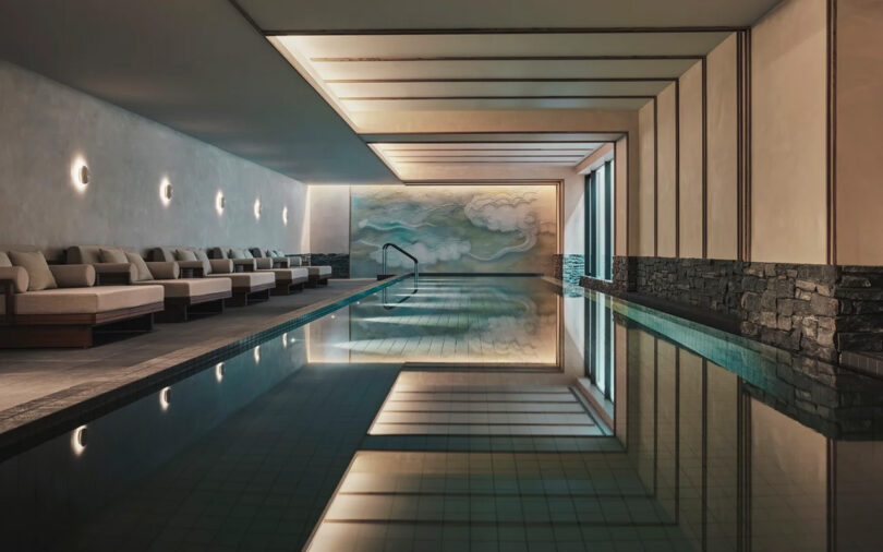 Indoor spa at the Six Senses Kyoto hotel with sleek design, featuring recliners on the side, dim wall lights, and a large abstract wall art at the end.