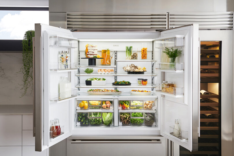 Open Sub-Zero refrigerator fully stocked and neatly organized.