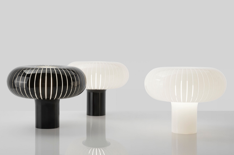 Three modern table lamps with mushroom-like shades, varying in color and design, against a neutral background.