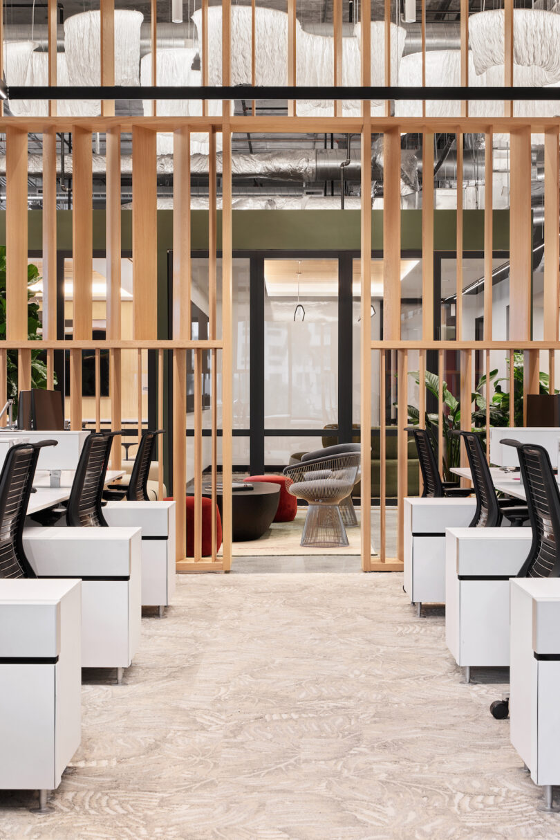rows of workstations with black task chairs and white storage cubes