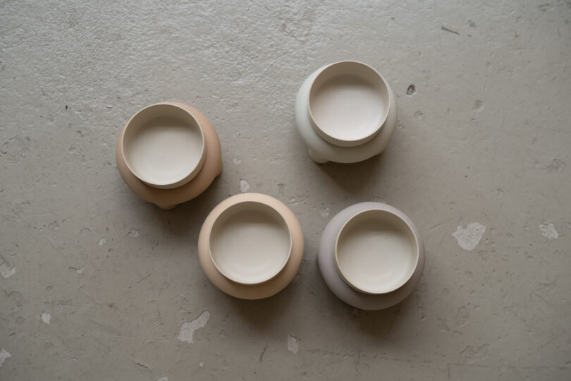 four pastel dog bowls on stands on the floor
