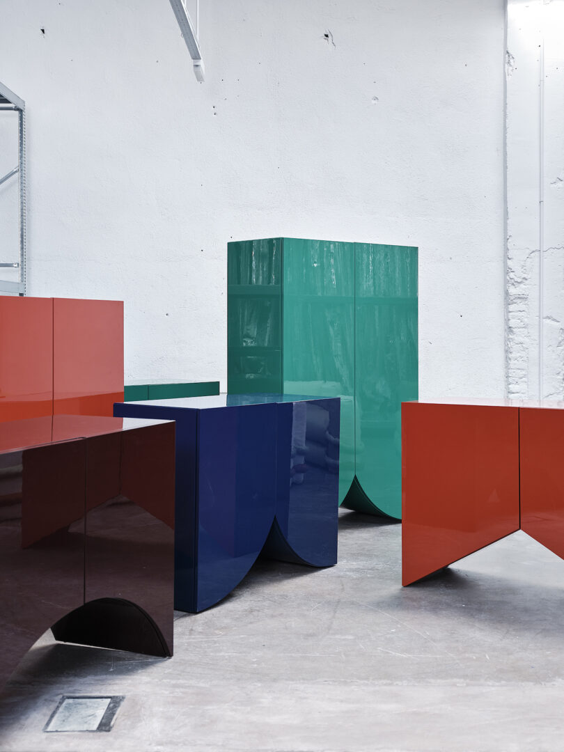 five cabinets with bases shaped like bridges on a concrete floor