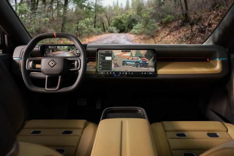 Interior view of a car with a digital dashboard display, steering wheel with logo, and tan leather seats, facing a wooded road