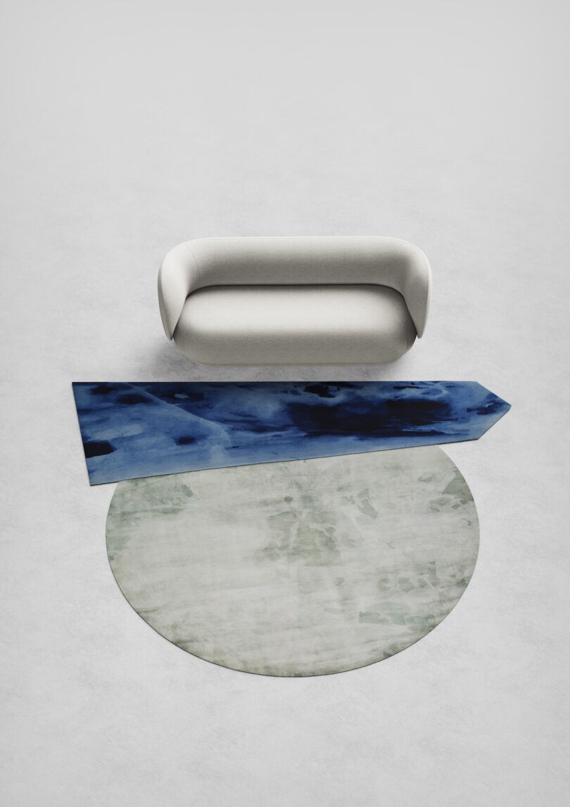 white sofa next to a blue and green rug