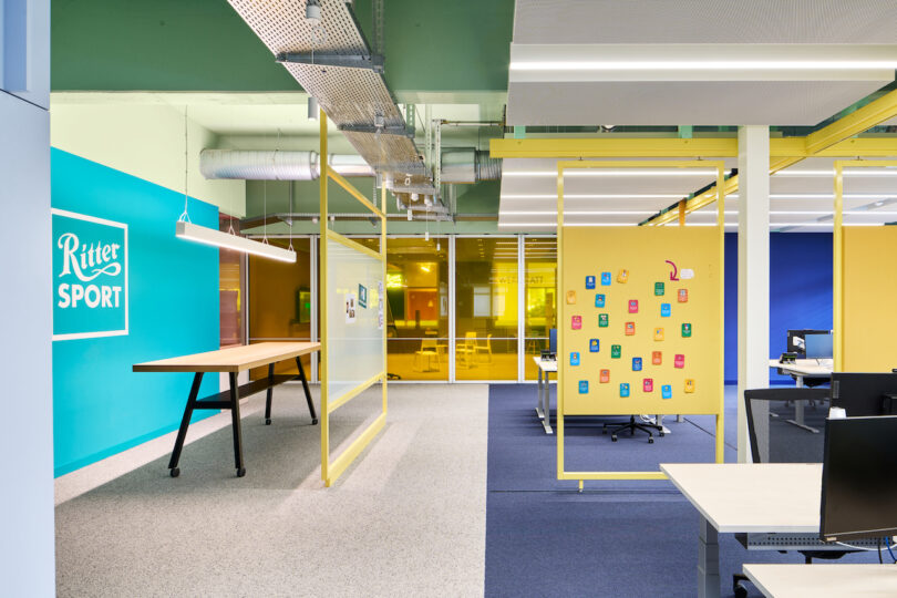 Modern office space featuring the ritter sport brand with vibrant interior colors, workstations, and an informal meeting area.