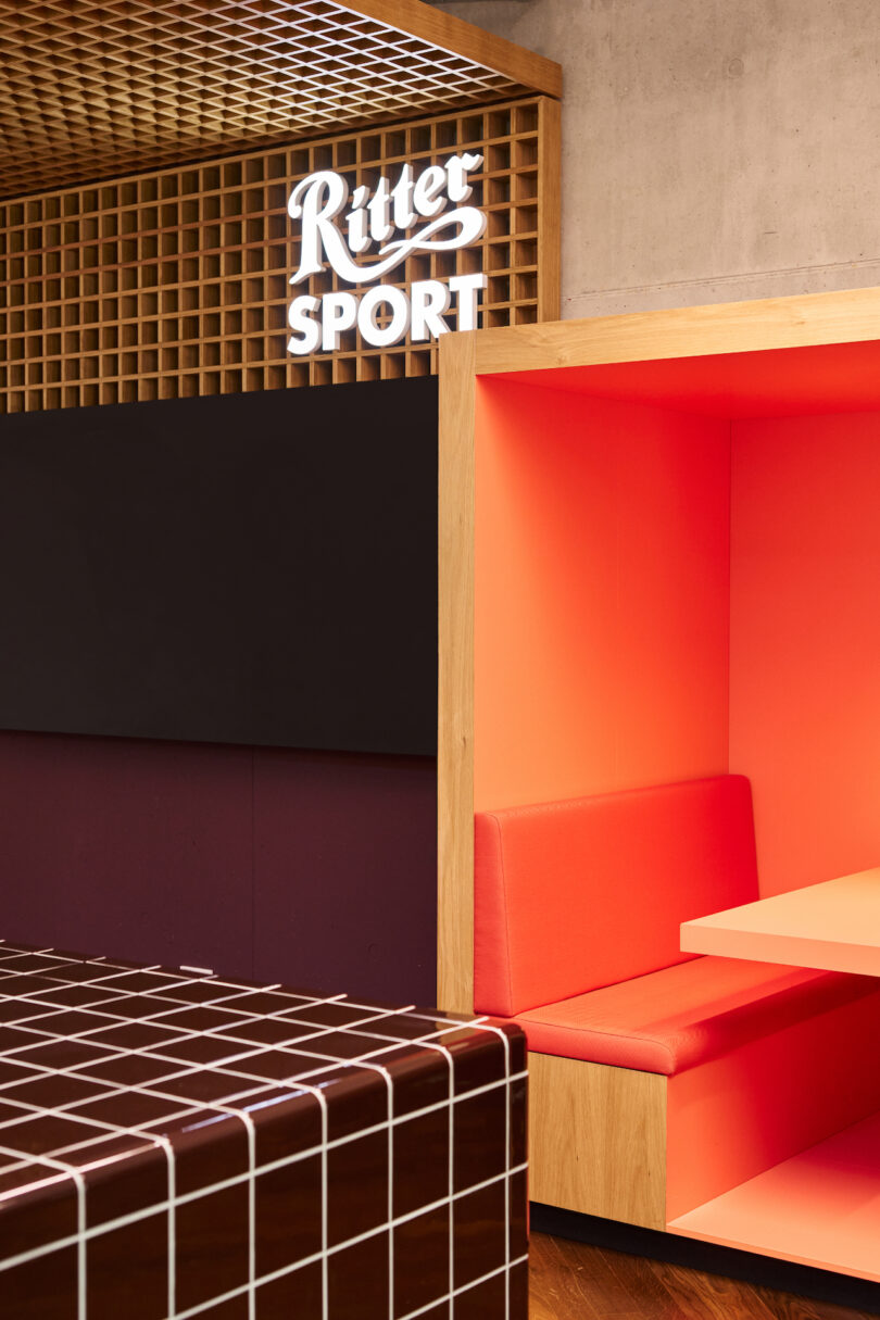 Interior of a modern seating area with the ritter sport logo displayed on the wall.