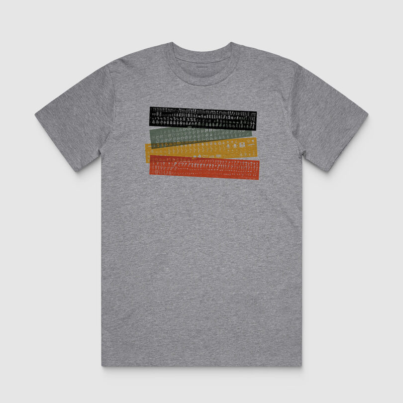 Gray t-shirt with a horizontal stripe design featuring five colors. each stripe contains a different pattern of small symbols.