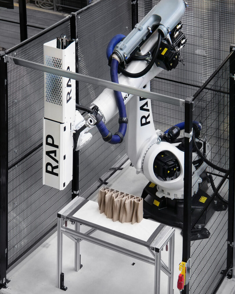 Down angled view of a robotic machine 3D printing ceramic bricks