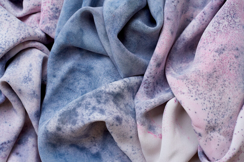 Close-up of fabric featuring a blend of pink and blue colors with a speckled pattern.