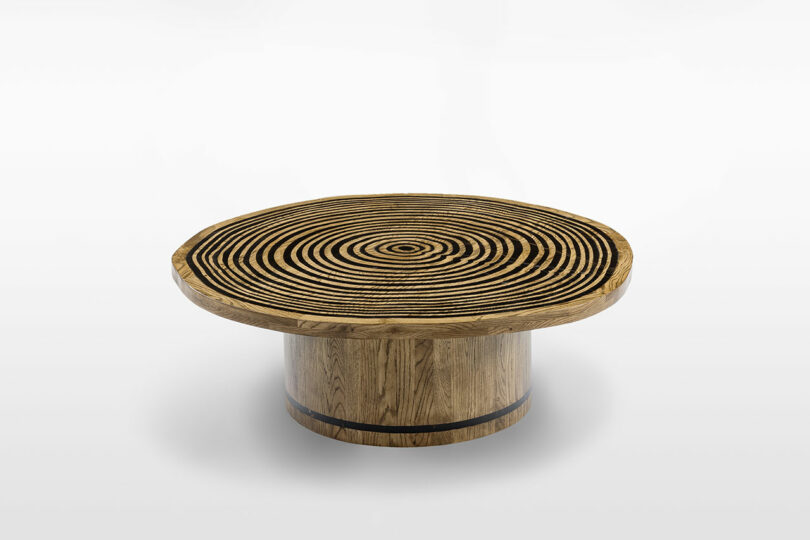 Round wooden stool featuring concentric black and natural wood circles on top, viewed from a slight angle against a white background, showcased at Design Miami.