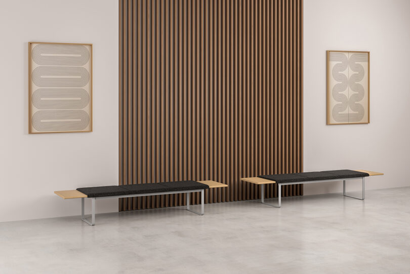 Modern waiting area with two black modular benches, wooden-slat wall feature, and abstract artwork.