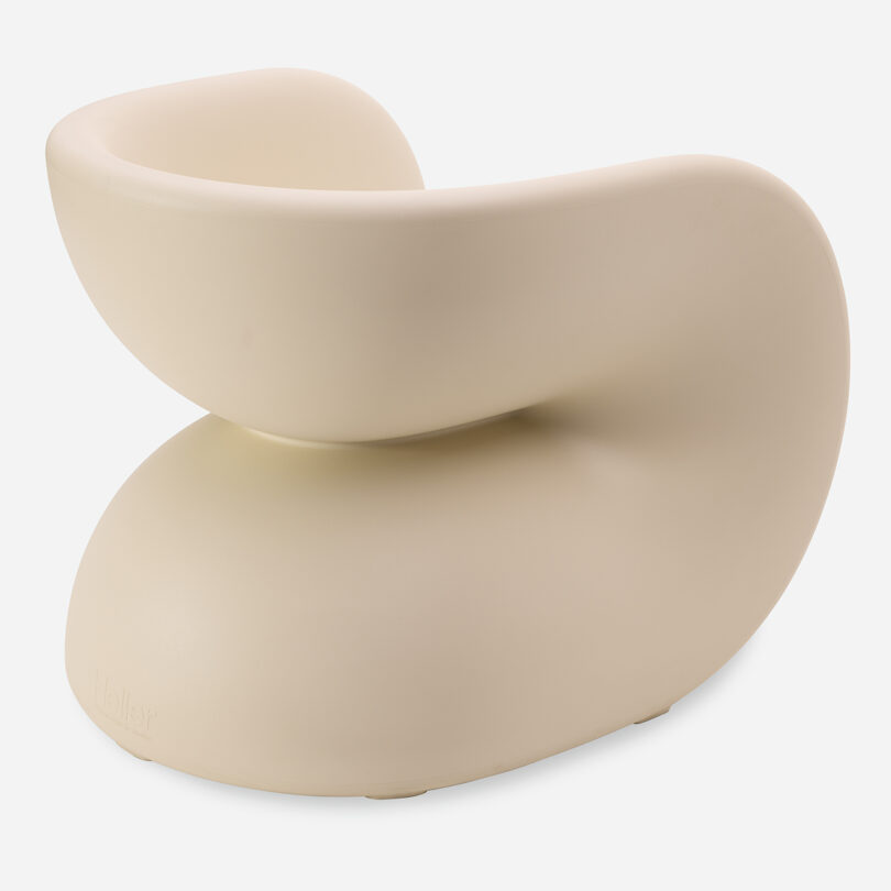 A modern cream chair with a curved, sculptural shape on a white background.