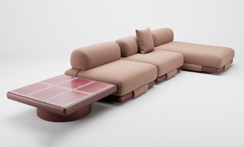 A modular pink sofa with a coffee table featuring a pink tiled surface, set against a plain white background.