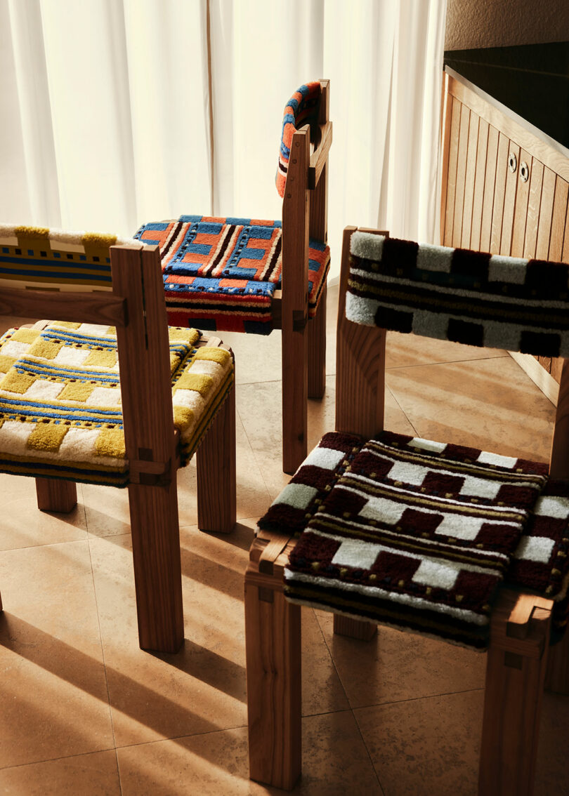 closeup view of three wood chairs with plaid woven seats