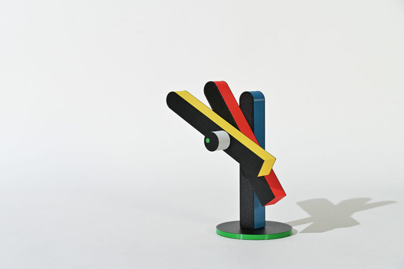 modern sculptural clock in primary colors on a stand