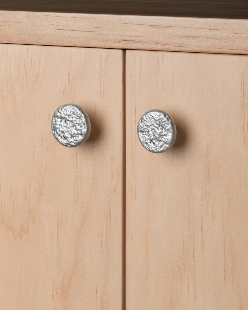Close-up of two cabinet doors with round metallic handles.