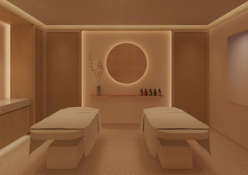 Minimalist Japanese-inspired spa room at The Emory Hotel, featuring two beige massage tables, wooden partitions, and a large circular wall decor.