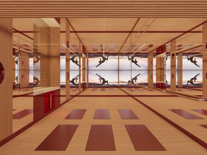 Modern gym and pilates studio with mirrored walls, wooden floors, and ballet barres at The Emory hotel, featuring people exercising, stretching and practicing in various poses.