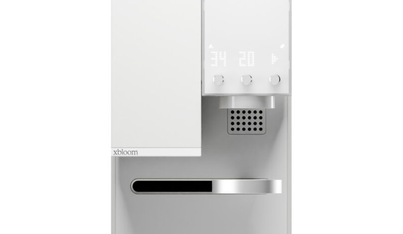 Close-up of a modern, white xBloom Studio coffee maker with a digital display and a front dispenser.