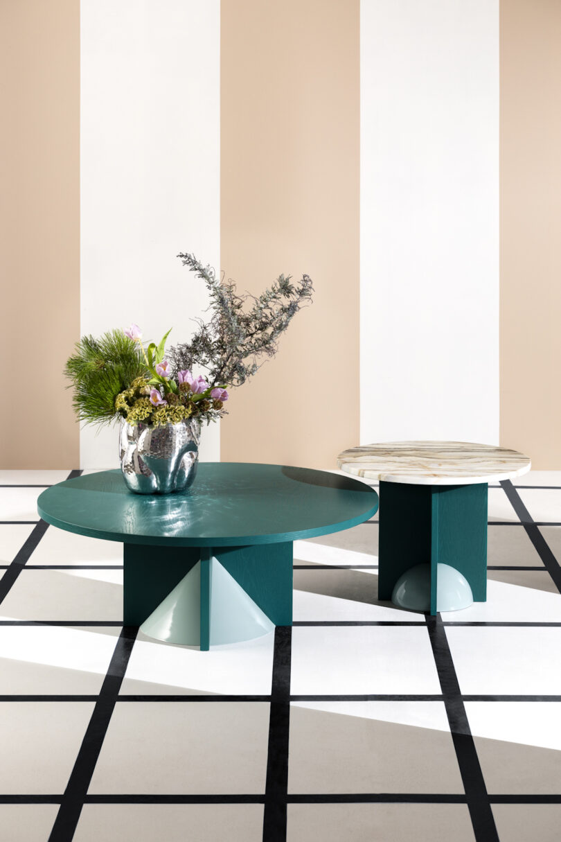 two teal coffee tables in a room with striped white and beige walls and square patterned floor