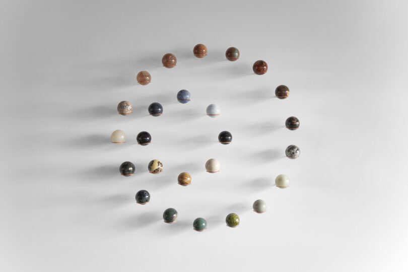 spheres of natural stones hanging on a wall arranged in two circles