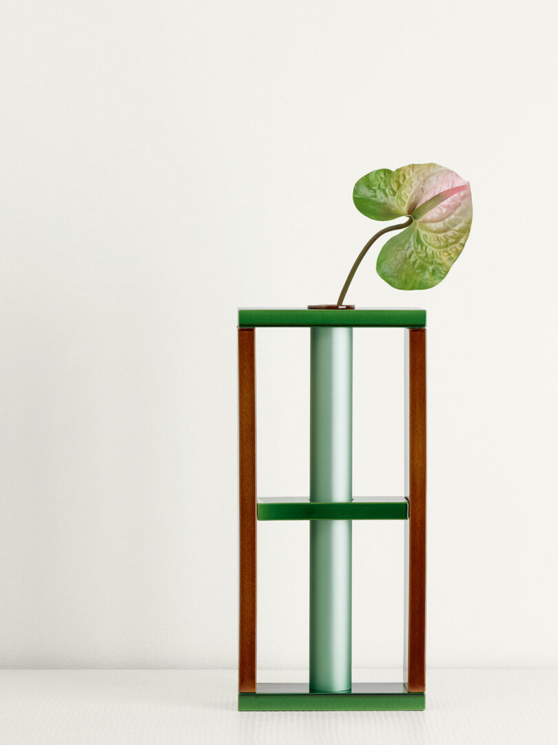 stem with one leaf inside metal vase with a ceramic framework