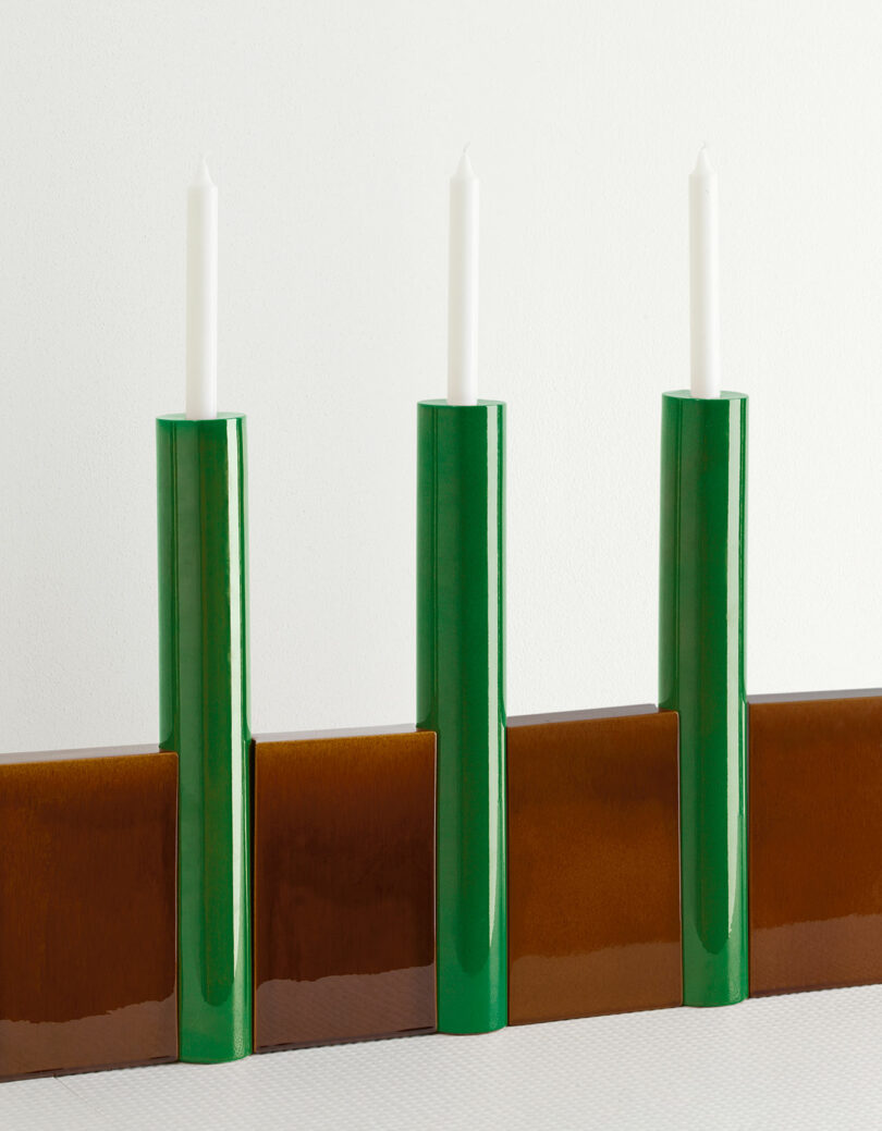 brown and green candelabra holding 3 white tapered candles