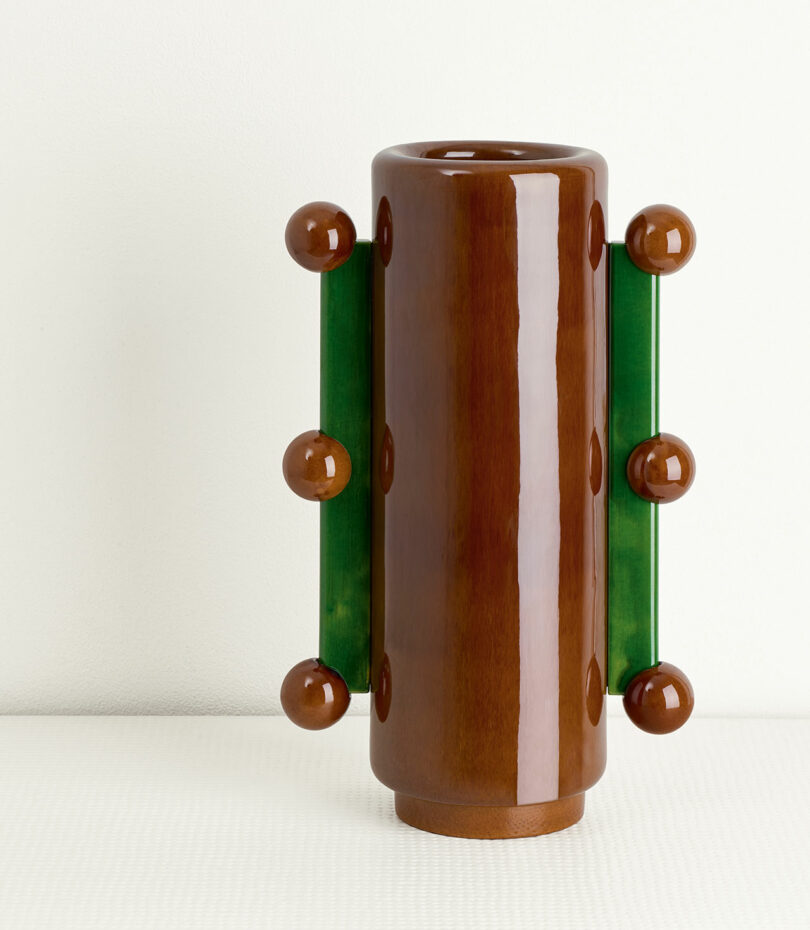 brown and green ceramic vase with protruding balls on the sides