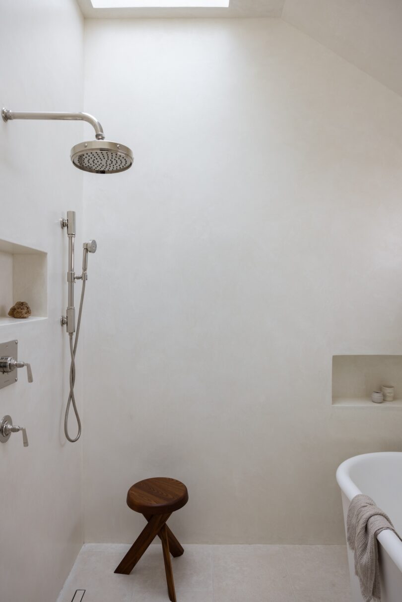 A minimalist bathroom with a walk-in shower featuring a large, round chrome showerhead.