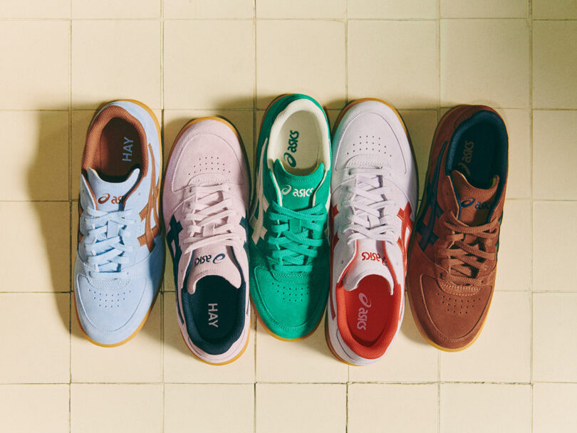 Five pairs of ASICS x HAY sneakers, each in different colors—light blue, pink, green, white, and brown—are placed side by side on a tiled floor.