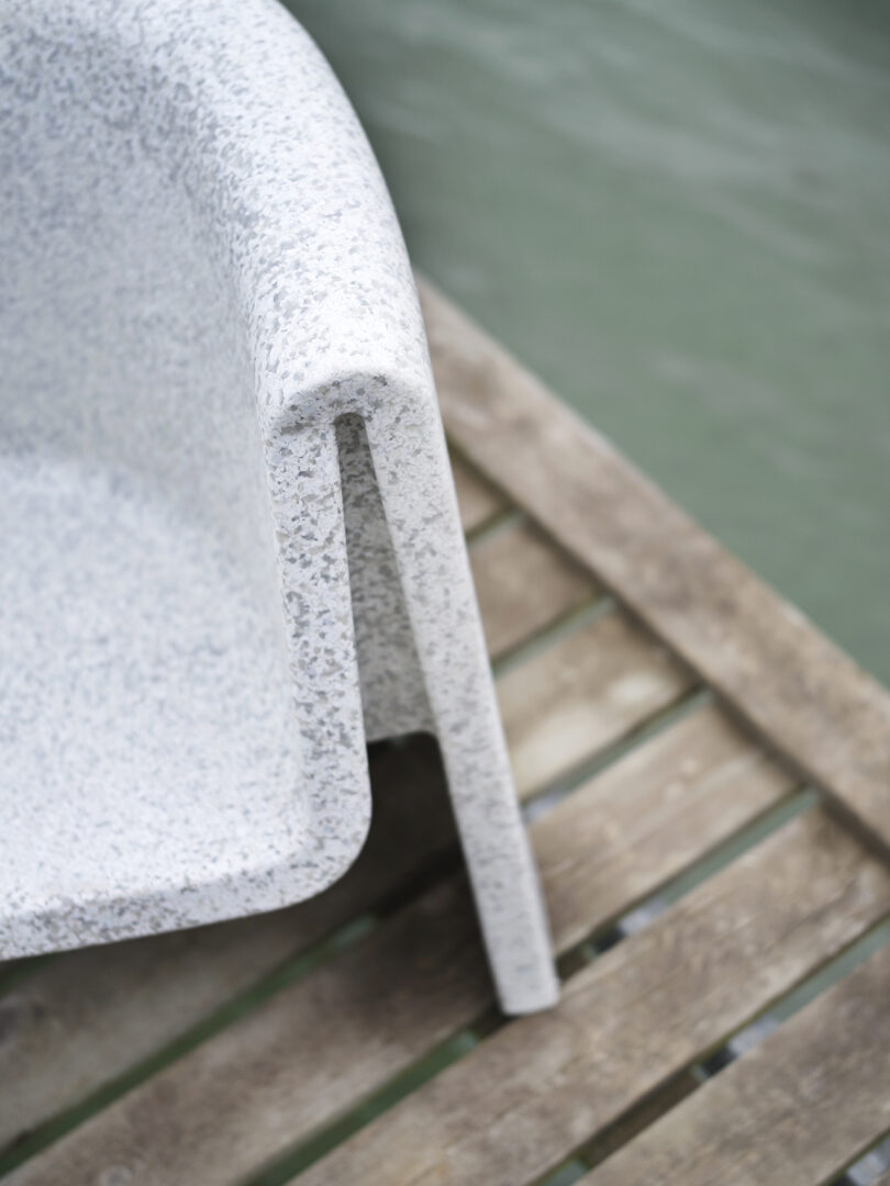 Detail of a white outdoor lounge chair placed on a dock.