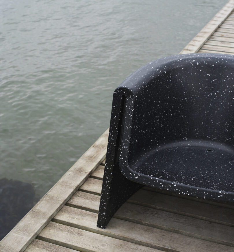 A black outdoor lounge chair placed on a dock.
