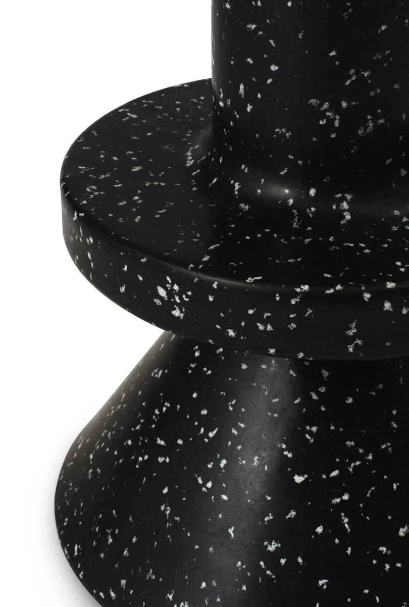 Detail of black outdoor barstool against a white background.