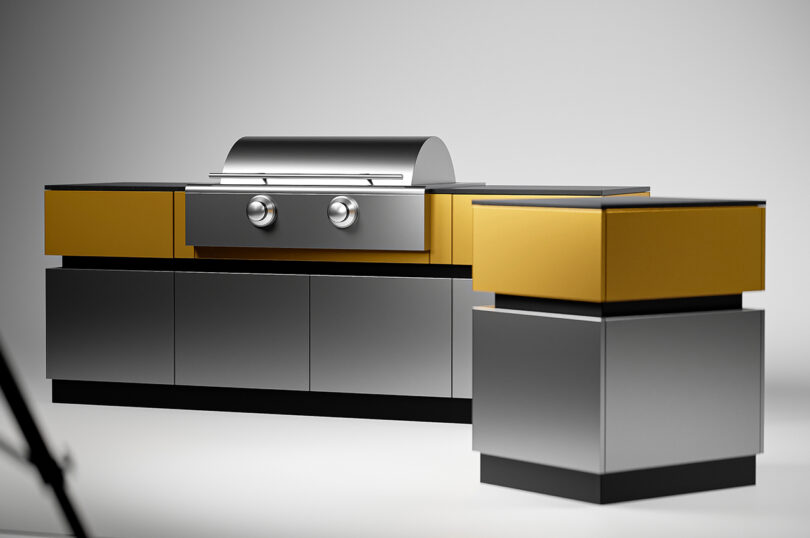 A modern stainless steel and yellow outdoor kitchen set with a built-in grill and storage cabinets, set against a plain white background.