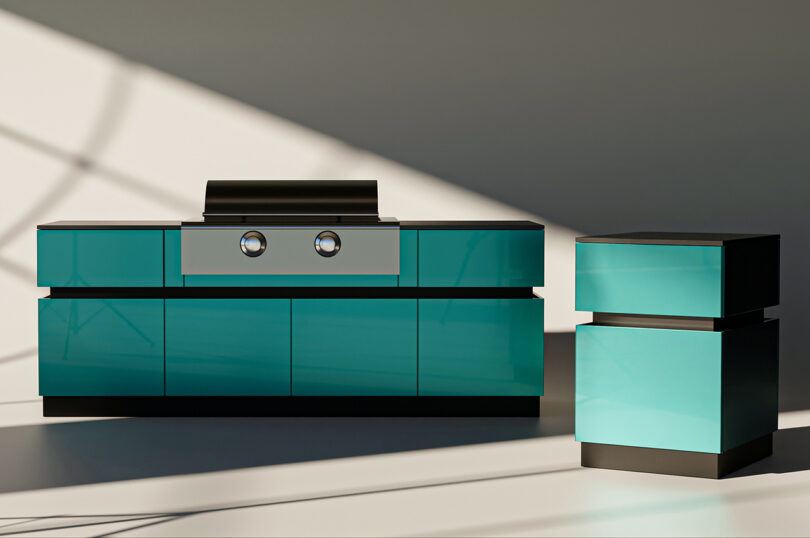 Modern teal outdoor kitchen with a built-in grill and a matching side cabinet in a sunlit setting.