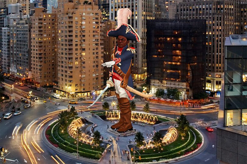 A large statue of a historical figure in military attire stands in the center of a busy city roundabout surrounded by buildings and light trails from moving vehicles at night.